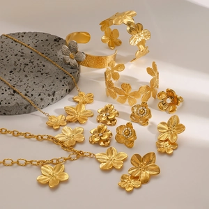 Elegant gold flower jewelry set with necklace, bracelet, ring and pearl earrings