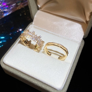 Close-up of 18k gold plated square zircon rings in a velvet box with soft bokeh lighting