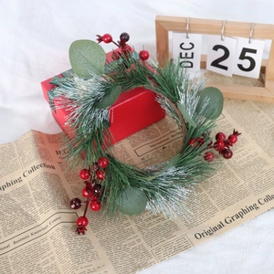 Close-up of Christmas candle ring with red berries, pine needles and eucalyptus leaves