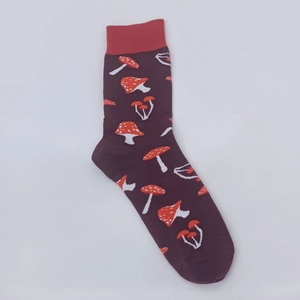 Detailed close-up of dark purple cotton socks with red mushrooms and ribbed cuffs