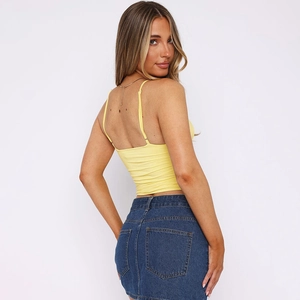Detail view of yellow V-neck crop top featuring ruched texture and open back design