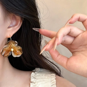 Detailed close-up of bohemian amber floral earrings with gold hooks on a model