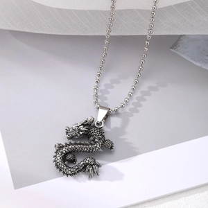 Detailed view of vintage silver dragon pendant with intricate punk style engravings