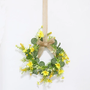 Easter floral wreath with yellow daisies, green leaves, and burlap bow on white background