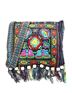 Detail of bohemian embroidery pattern with colorful tassels and white wooden beads