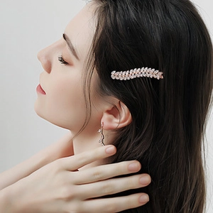 Detail of elegant silver leaf bridal hair clip and matching rhinestone drop earrings set