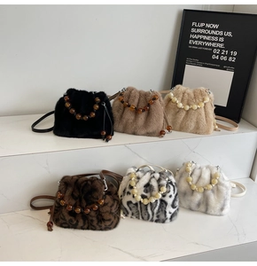Detail of plush bucket bags with bead handles arranged on marble stairs for display