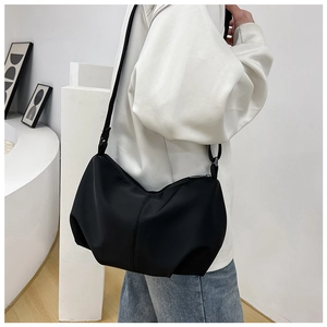 Detail of minimalist black pleated dumpling bag showing soft drape and high-density matte fabric