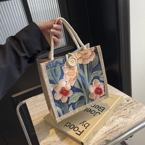 Close-up of linen tote bag with retro tropical floral print and white rope handles