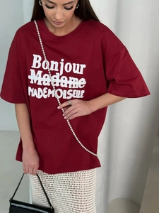 Close-up of oversized burgundy cotton T-shirt with Bonjour Madame graphic print