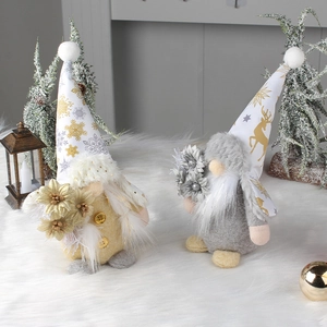 Set of two decorative Christmas gnomes with gold deer patterns on fur rug with pine trees