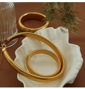 Golden chunky screw link jewelry set with necklace and bracelets in shell tray