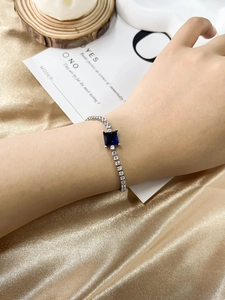 Detail of silver bracelet with a large square blue sapphire-like gem and pavé cubic zirconia