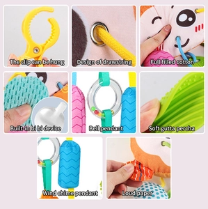 Détail d'un jouet de poussette en peluche avec anneau de dentition et grelots sonores
