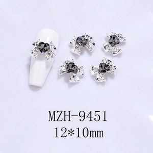 Detailed view of silver alloy bow nail charms with grey heart-shaped gemstone, 12x10mm