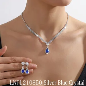 Close-up of teardrop blue crystal necklace and earring set on a model for evening wear
