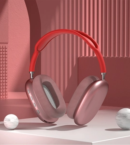 Detail view of pink wireless over-ear headphones with mesh ear pads on aesthetic stage