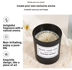 Matte black glass scented candle on stone pedestal with daisy flowers decoration
