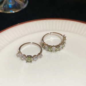Macro view of vintage silver rings with olive green gems and sparkling crystals