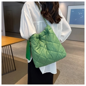 Vista dettagliata della borsa tote verde trapuntata con spalline a catena e mini pochette