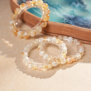Détail macro de bracelets en perles de cristal jaune naturel sur un plateau en bois chic