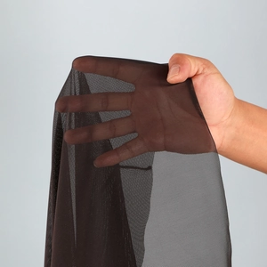 Macro detail of breathable dark coffee mesh fabric showing high elasticity and transparency