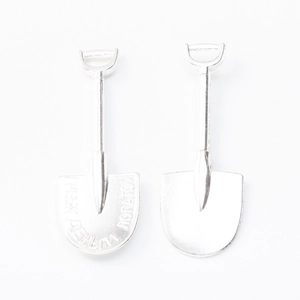Macro shot of silver vintage shovel charms with Russian engraving and smooth metal finish