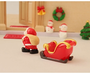 Detailed close-up of resin Santa Claus figurine with red sleigh in a Christmas scene
