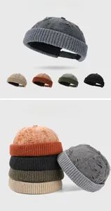 Detailed view of distressed knit beanies in gray, khaki, orange, army green and black colors