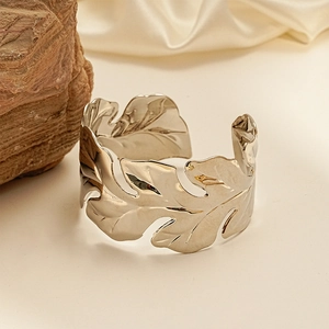 Silver metallic leaf-shaped open cuff bracelet with detailed texture and organic design