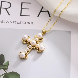 Macro shot of gold cross pendant with intricate white pearls and vintage baroque style