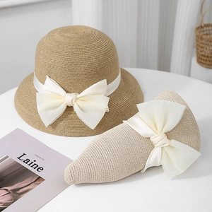 Women's foldable straw sun hat with large white satin bow for beach vacation UV protection