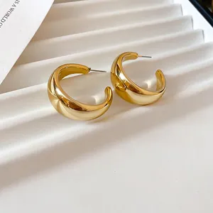 Minimalist chunky golden C-shaped acrylic hoop earrings with polished mirror finish
