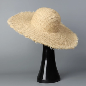 Détail d'un chapeau de soleil en paille à larges bords avec bords effilochés décoratifs
