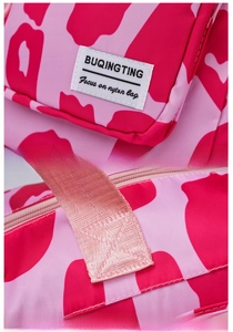 Close-up of pink animal print nylon travel bag showing logo and reinforced stitching
