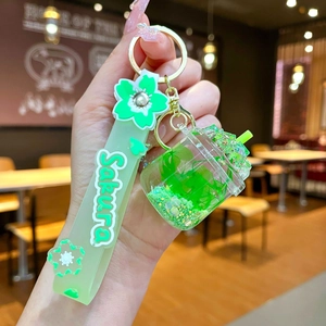 Close-up of green Sakura cherry blossom liquid oil keychain with silicone wristband