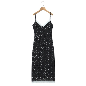 Robe longue à pois avec bordure en dentelle blanche sur un cintre en bois