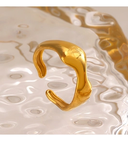 Macro shot of gold irregular wave open ring on textured glass with water reflections