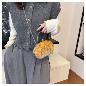 Detail of pumpkin shaped handbag with orange slices design and sparkling glitter texture