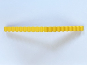 Detail view of a yellow plastic chip clip with a wavy edge for creative food sealing