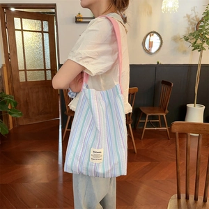 Détail du sac fourre-tout en seersucker à rayures bleues et bandoulière rose