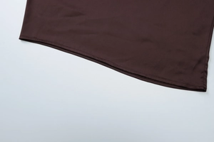 Gros plan détaillé sur l'ourlet et les coutures de la robe en maille marron foncé