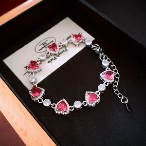 Detail of pink heart-shaped crystal bracelet with zircon halo in a luxury jewelry box