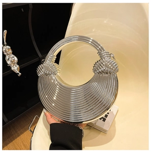 Detailaufnahme der silbernen Knotentasche mit strukturierter Metalloberfläche und Kette