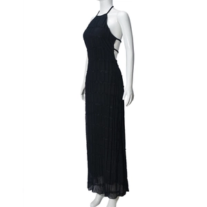 Side view of backless black halter maxi dress with pleated texture on a white background