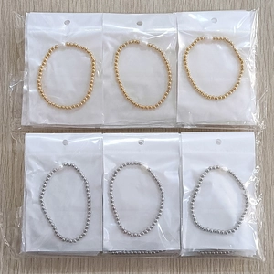 Detail view of gold and silver beaded bracelets with freshwater pearls in packaging