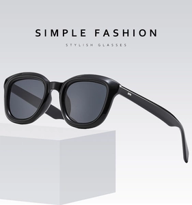 Detailed close-up of glossy black square sunglasses frames with silver temple accents