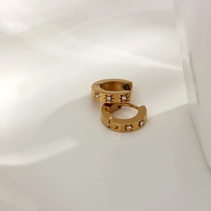 Detail of 18K gold-plated huggie hoop earrings with starburst star-set zircon stones