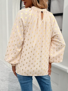 Detail view of pink long sleeve blouse featuring golden polka dots and back teardrop cutout