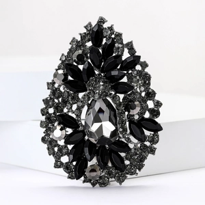 Macro detail of vintage water drop brooch with black crystals and ornate rhinestones